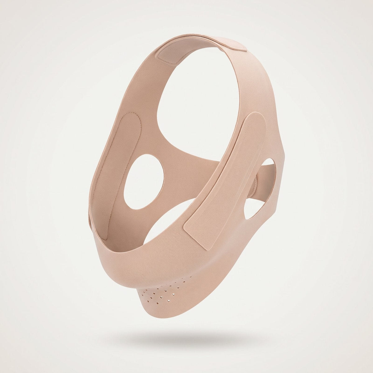 Nude soft-fabric facial contouring wrap on a pale studio background