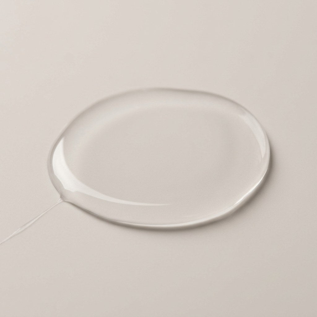 A thin pool of the clear, light serum on a pale surface