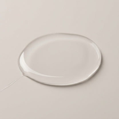 A thin pool of the clear, light serum on a pale surface