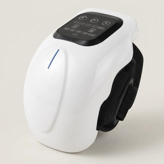 White moulded knee and joint massager with its black touch panel and strap, on a pale studio background
