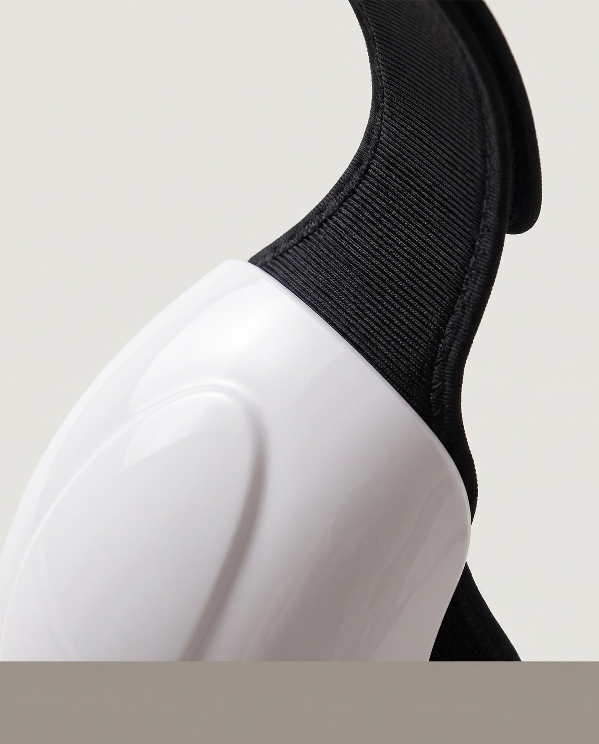 Close view of the flexible black strap where it meets the rigid white shell
