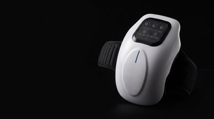 The white joint massager lit against a black background