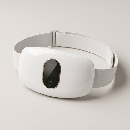 White cordless waist massager on its wide elastic strap, on a pale studio background